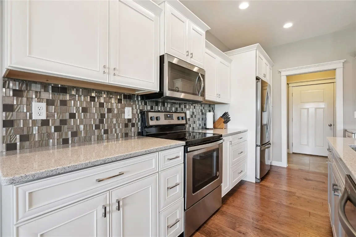 Quality cabinets with quartz counter tops and glass tile backsplash
