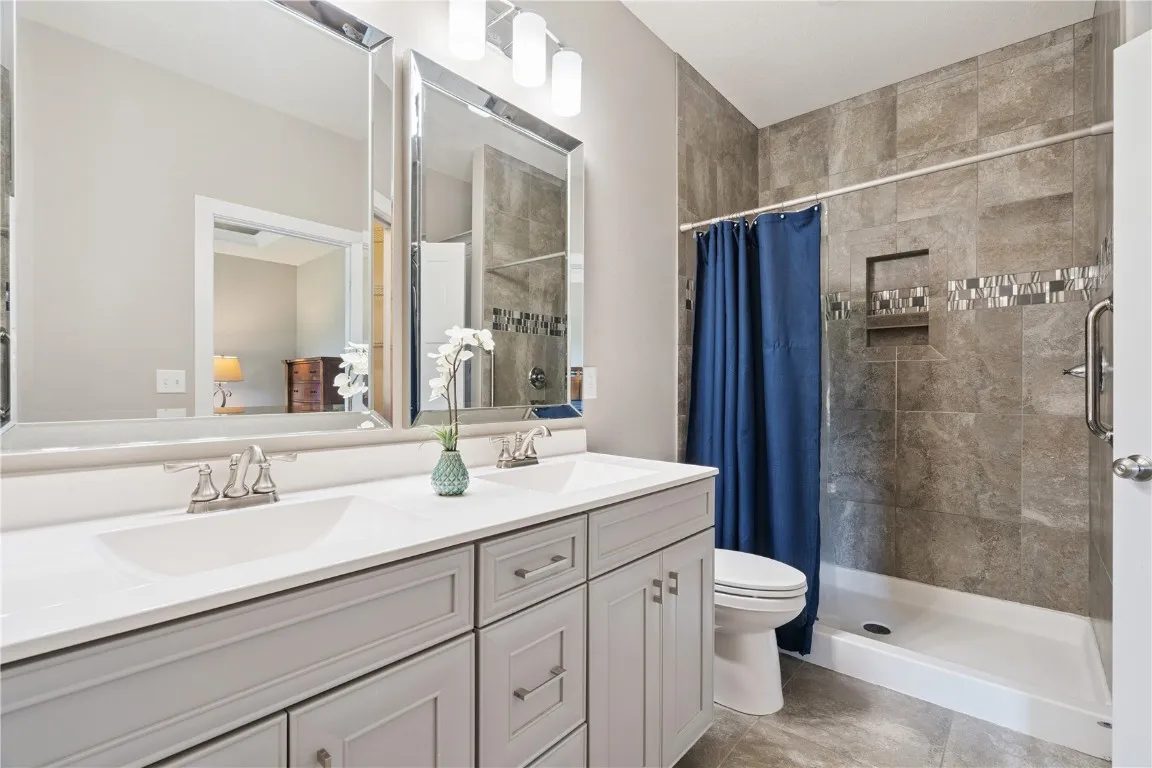 Primary bath with tiled shower, double sinks and walk-in closet