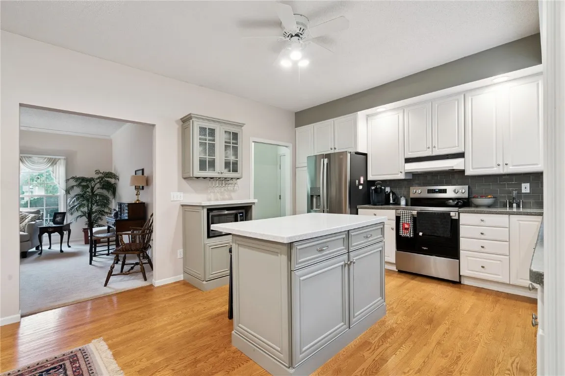 Kitchen adjacent to the sunroom with door to deck. Original hardwood floors.