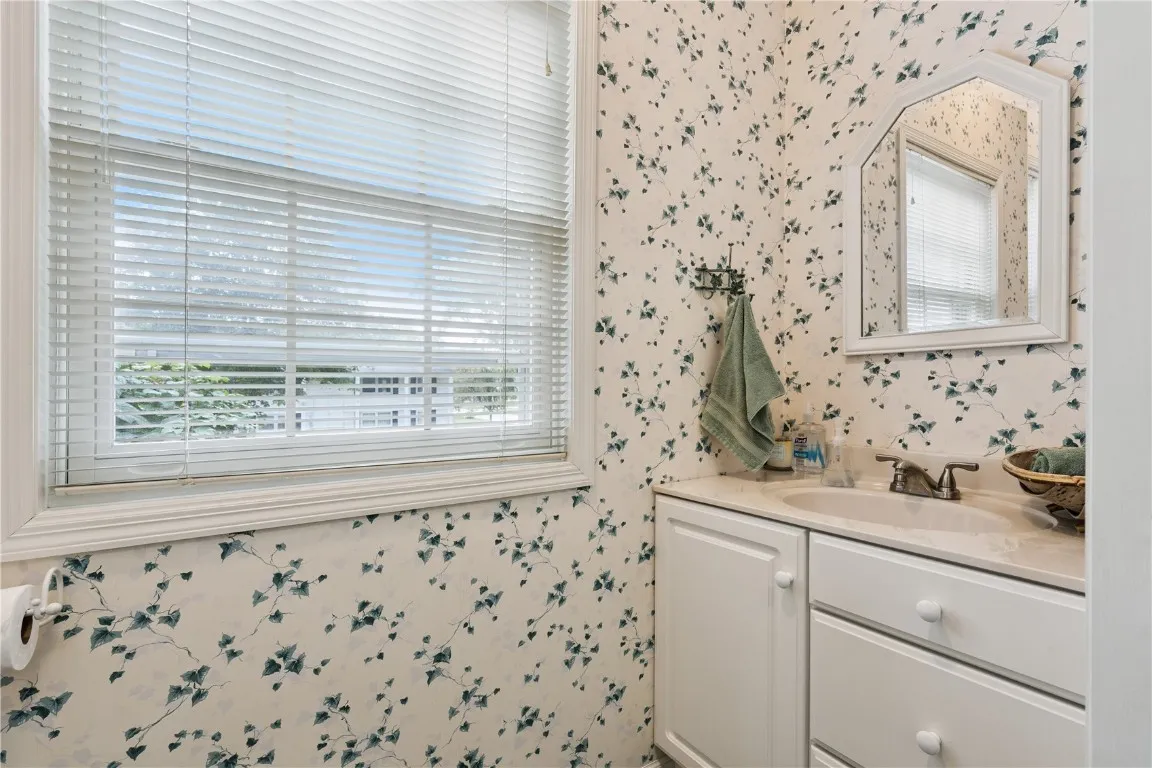 1st floor half bath with vanity and toilet with privacy pocket door to laundry