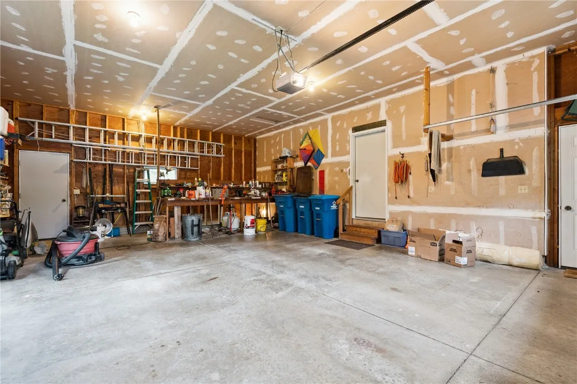 Garage with doors to house, backyard and stairs to house basement