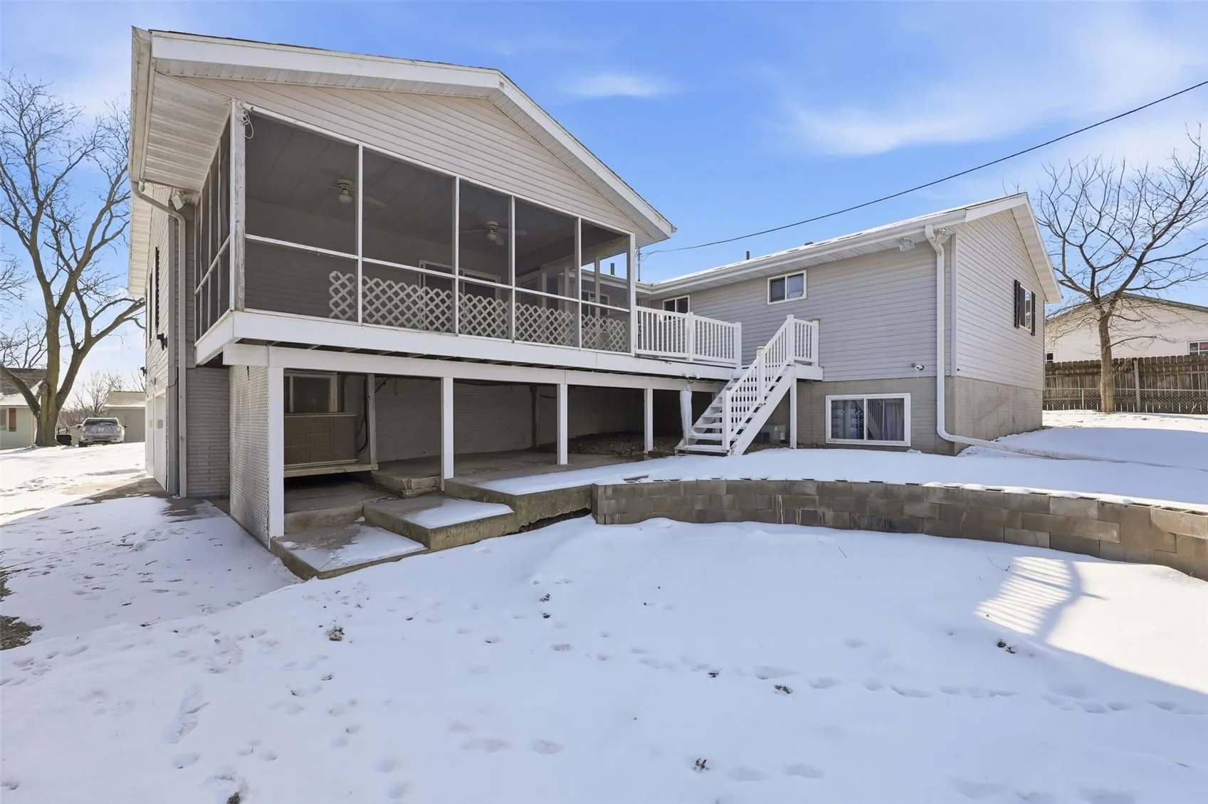 Rear view shows an open deck with steps to yard plus a covered patio.