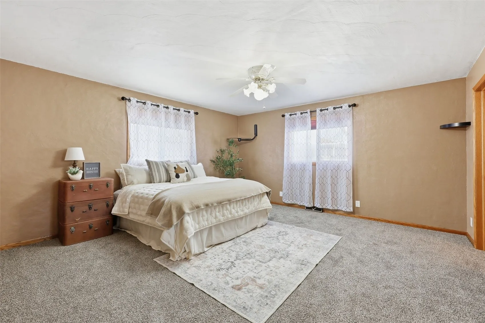 Spacious primary suite easily supports a king bed and additional furniture pieces.