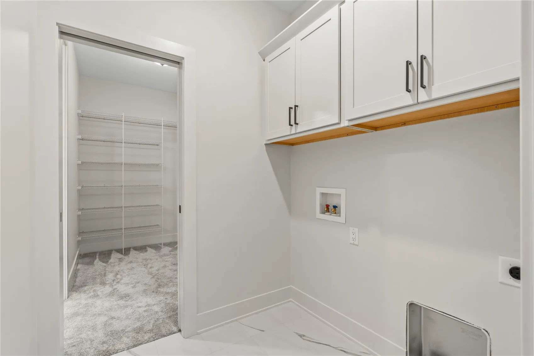 Laundry room located just off primary bedroom walk-in closet.