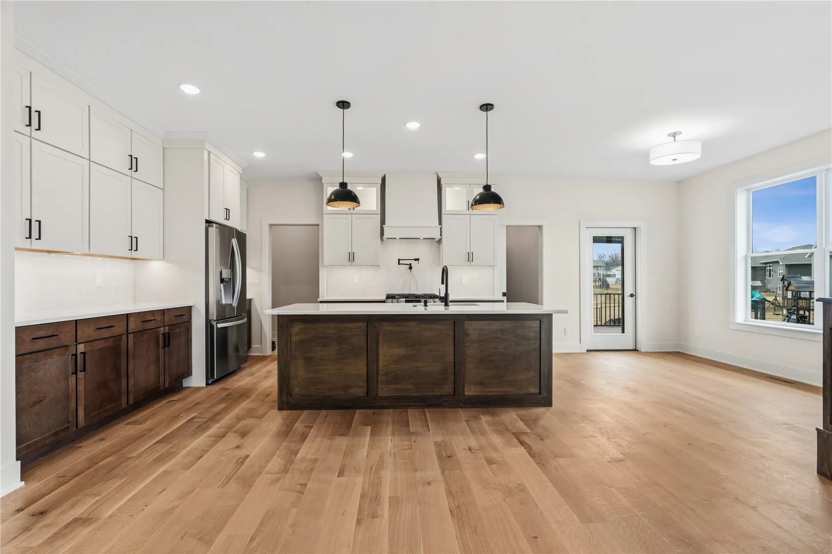 Sleek quartz countertops, ample amount of kitchen storage, custom stove hood vent, & pot filler!