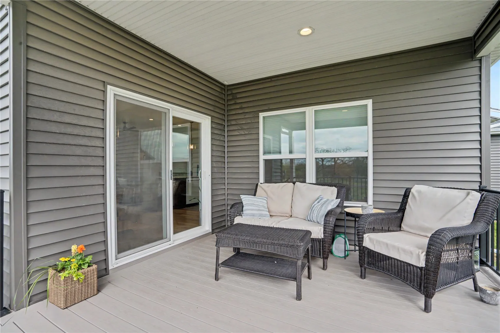 Covered deck off of dining area with stairs leading to patio and gas fire pit