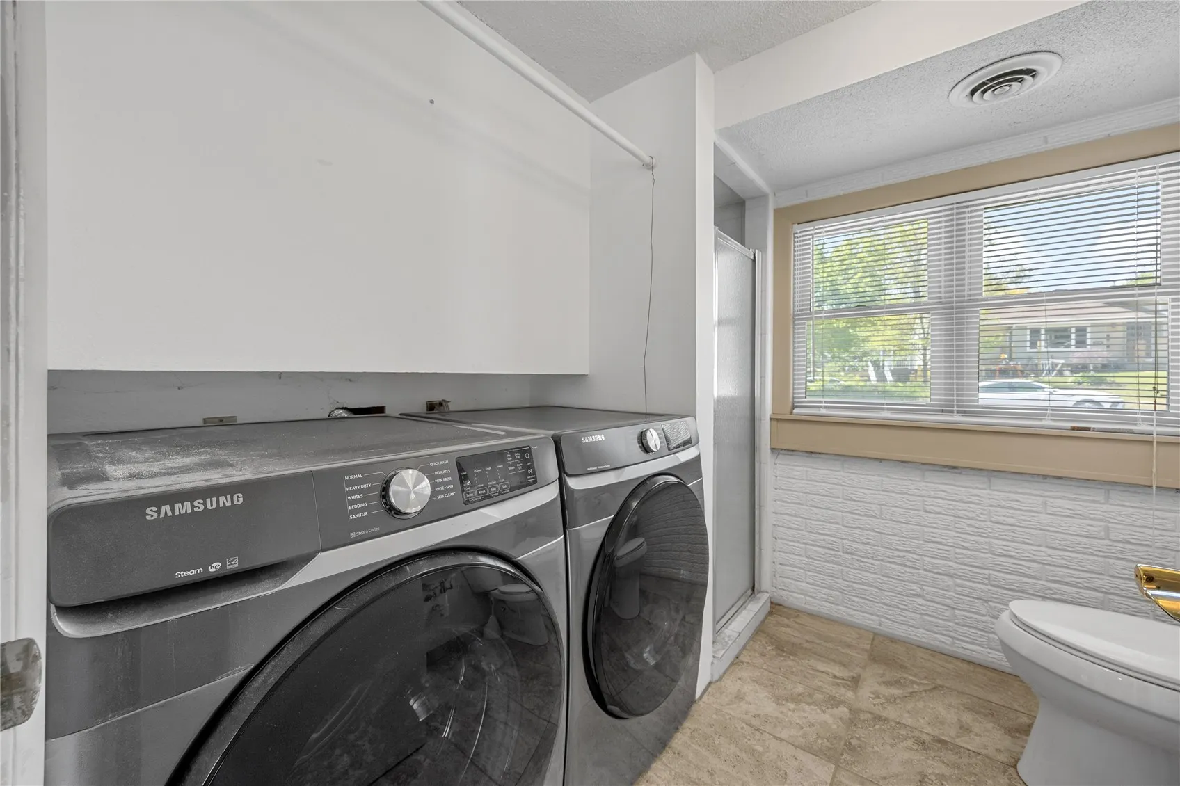 Located to the left as one goes down the steps is the laundery room and a full bath with shower.