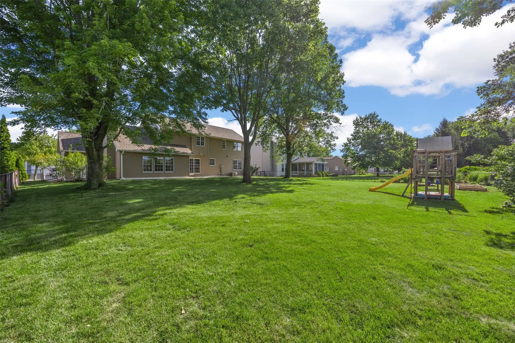 Fenced In Backyard with Swing Set and Garden Plots
