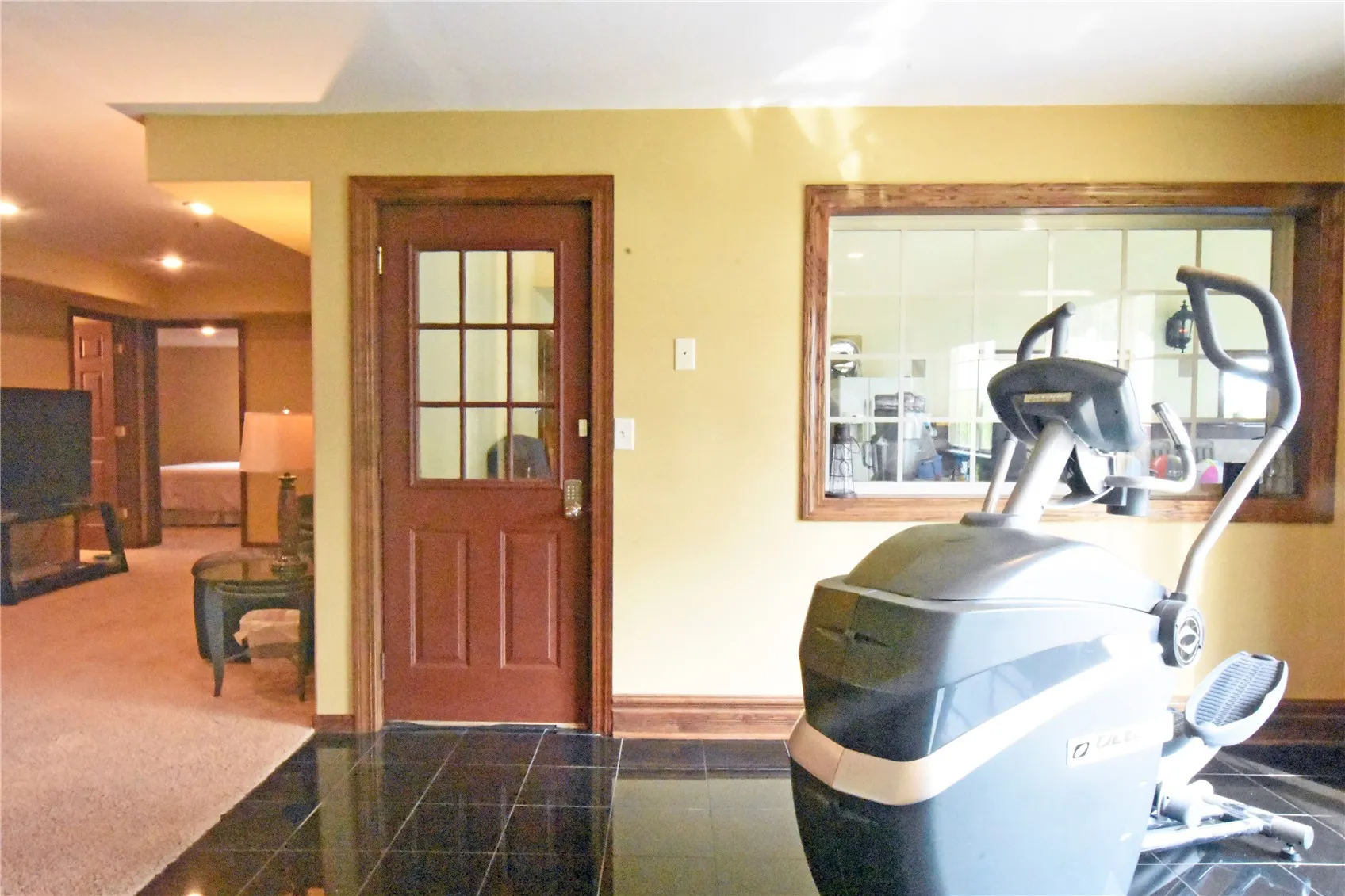 Florida room with black tile and entry to pool