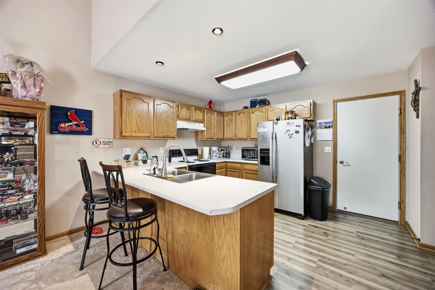 BREAKFAST BAR INTO KITCHEN. GARAGE DOOR IS TO THE RIGHT,