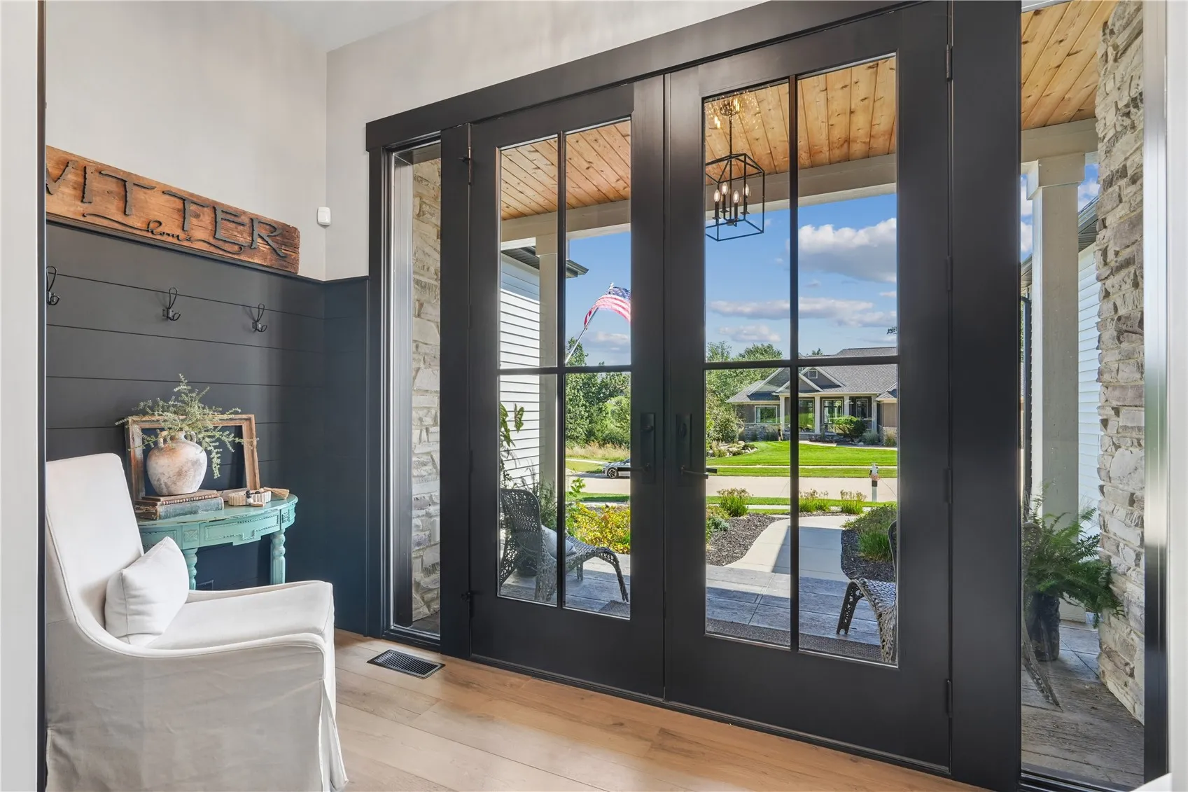 What an impressive foyer drenched in natural light and highlighted with black shiplap  and 8 ft doors. Magnificent!
