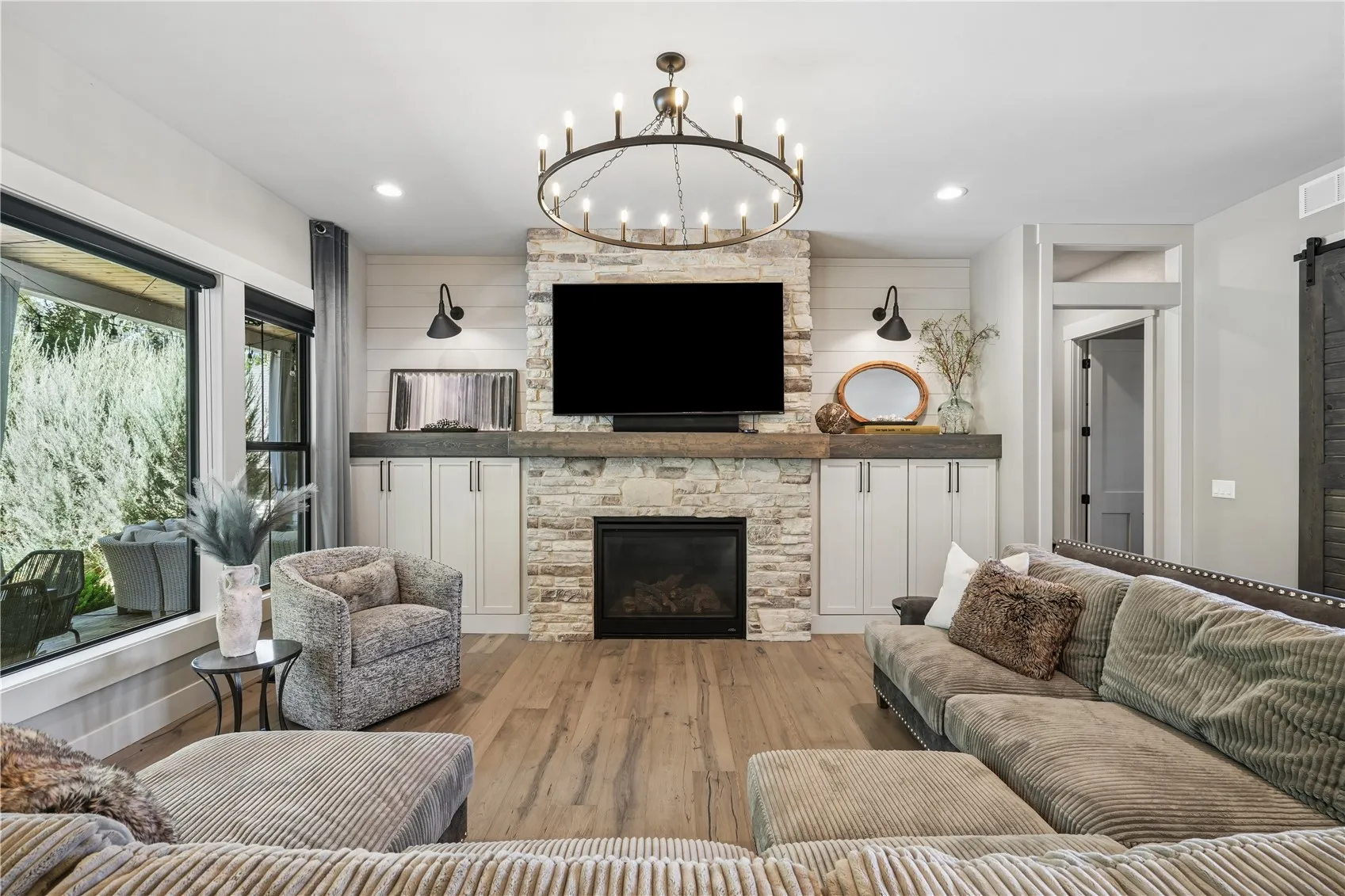 Oversized floor to ceiling stone gas fireplace with custom mantel and built-ins is most impressive.