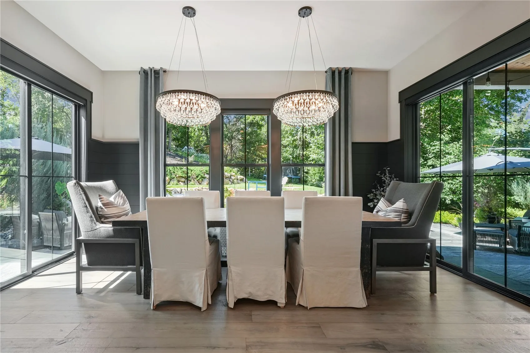 Dining area surrounded by natural light and highlighted by black shiplap. Yes, your table and chairs will fit comfortably.