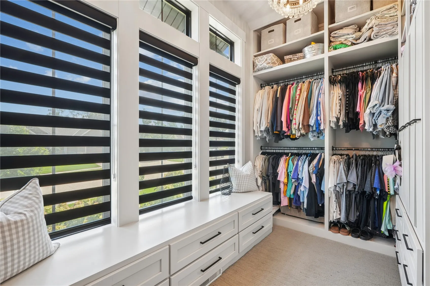Primary walk-in closet    with plenty of storage, pull down clothes bar and custom blinds.