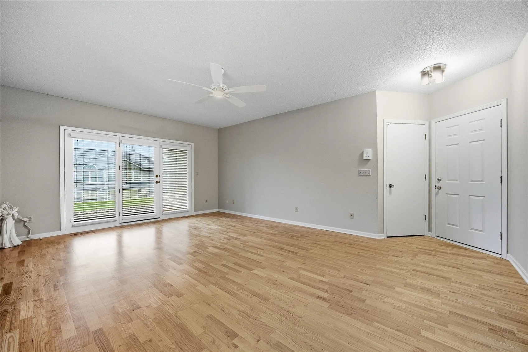 Living room with three full size windows. The custonm blinds stay.