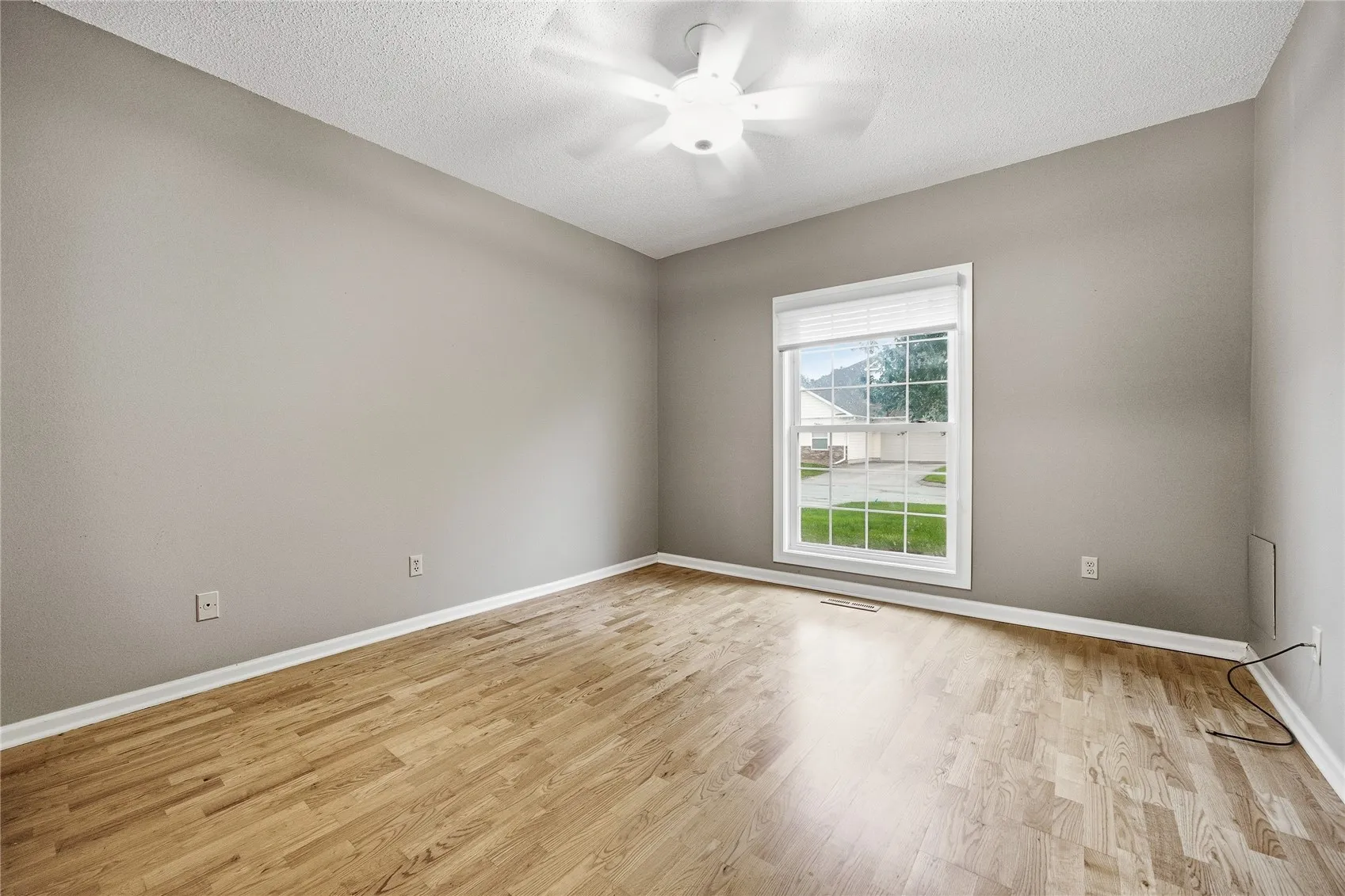 Bedroom #2 with woood floor and large windo. Yes, the custom blinds stay!