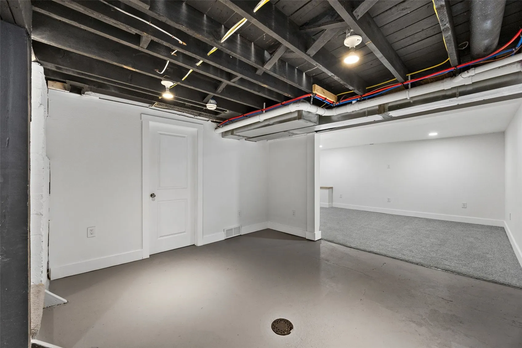 Clean dry basement with view of storage room and rec room