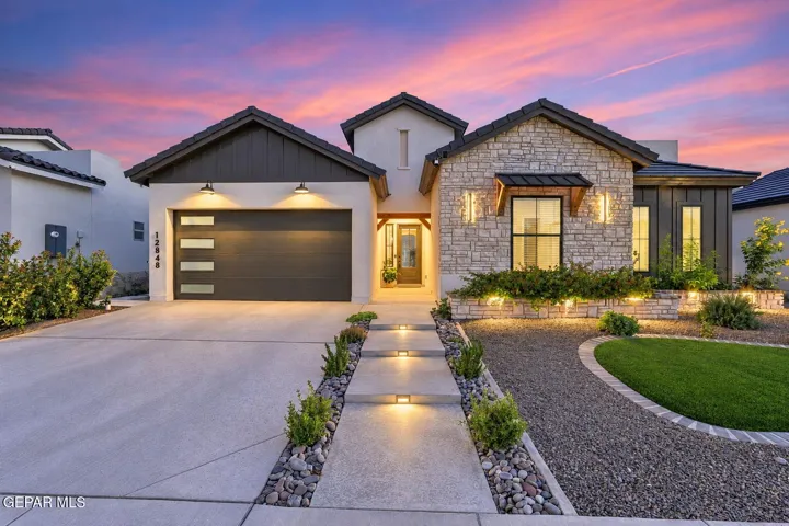 Gorgeous curb appeal with custom landscaping and lighting!