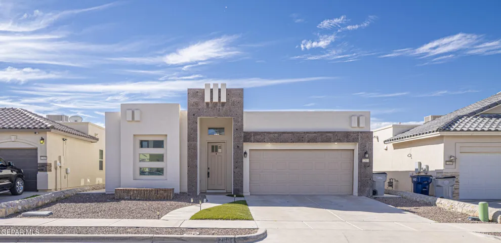 Contemporary exterior featuring a textured stone facade, smooth stucco finish, geometric architectural accents, and an attached double-car garage