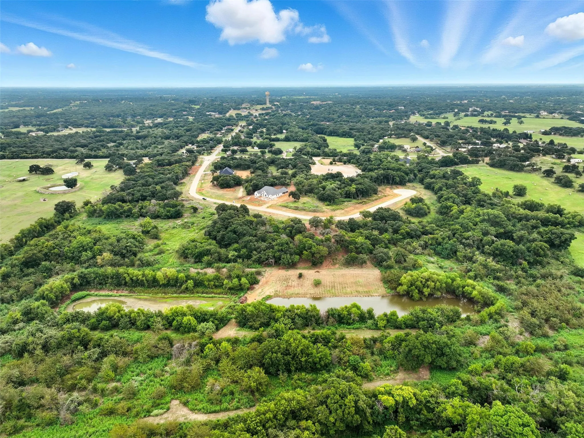 View of property location with a large body of water and a tree filled landscape