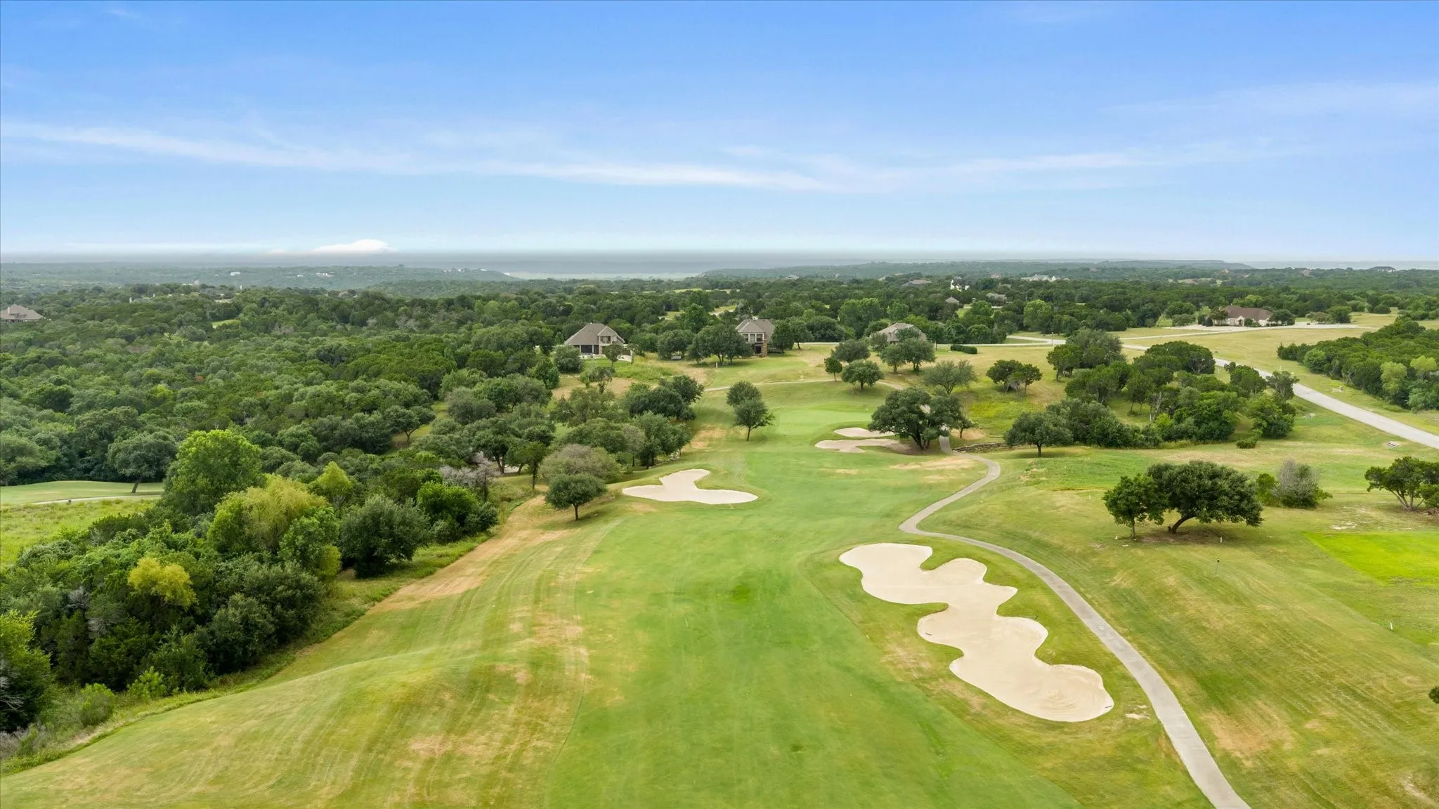 Expansive golf course property featuring green fairways, sand traps, and mature trees