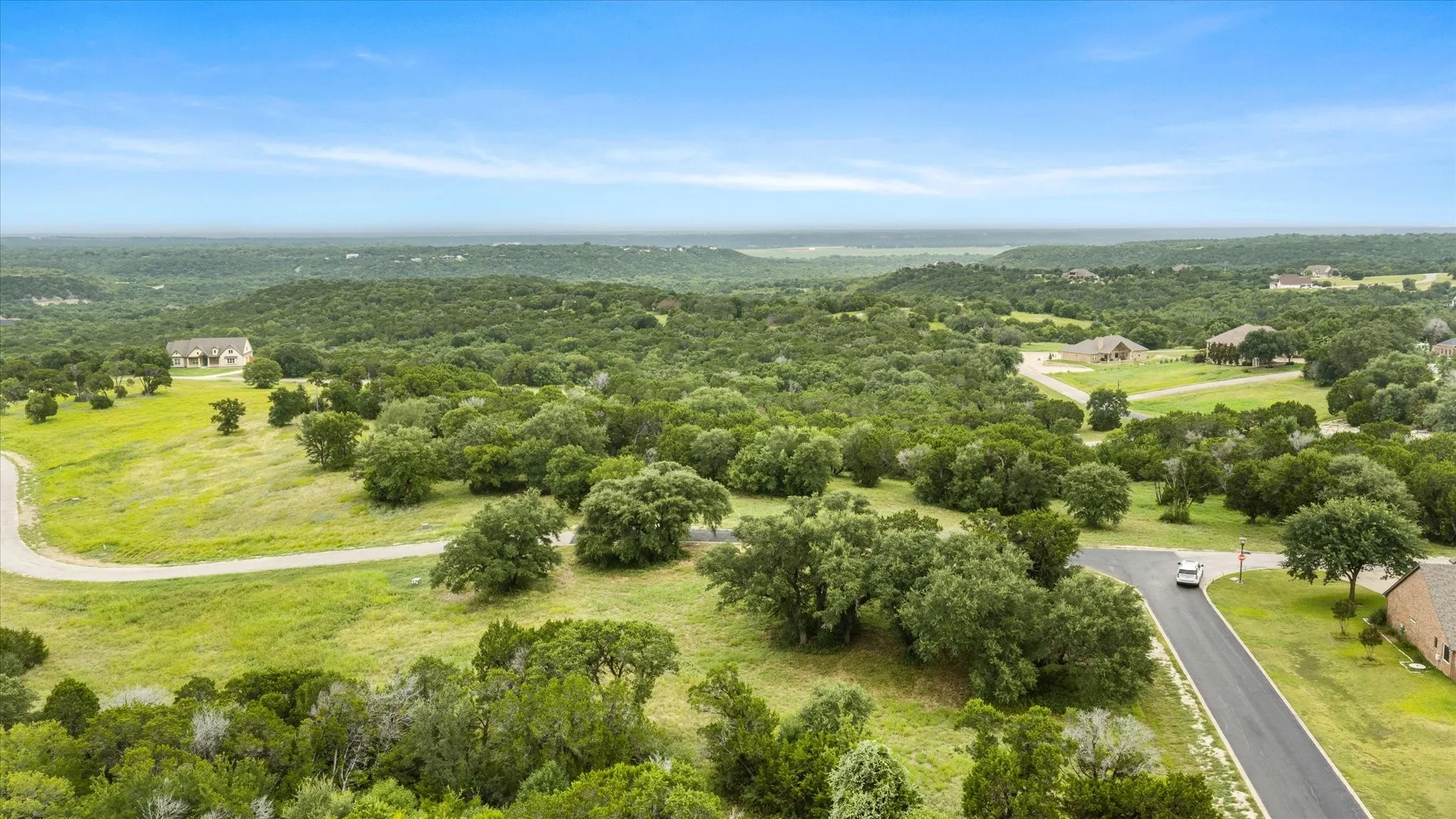Expansive rural landscape featuring established trees and rolling topography