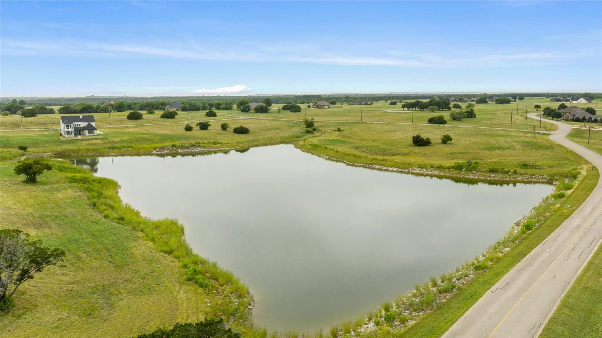 Expansive private lake with surrounding green landscape