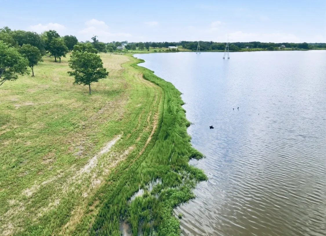 Expansive waterfront property featuring a gently sloping, grass-covered terrain