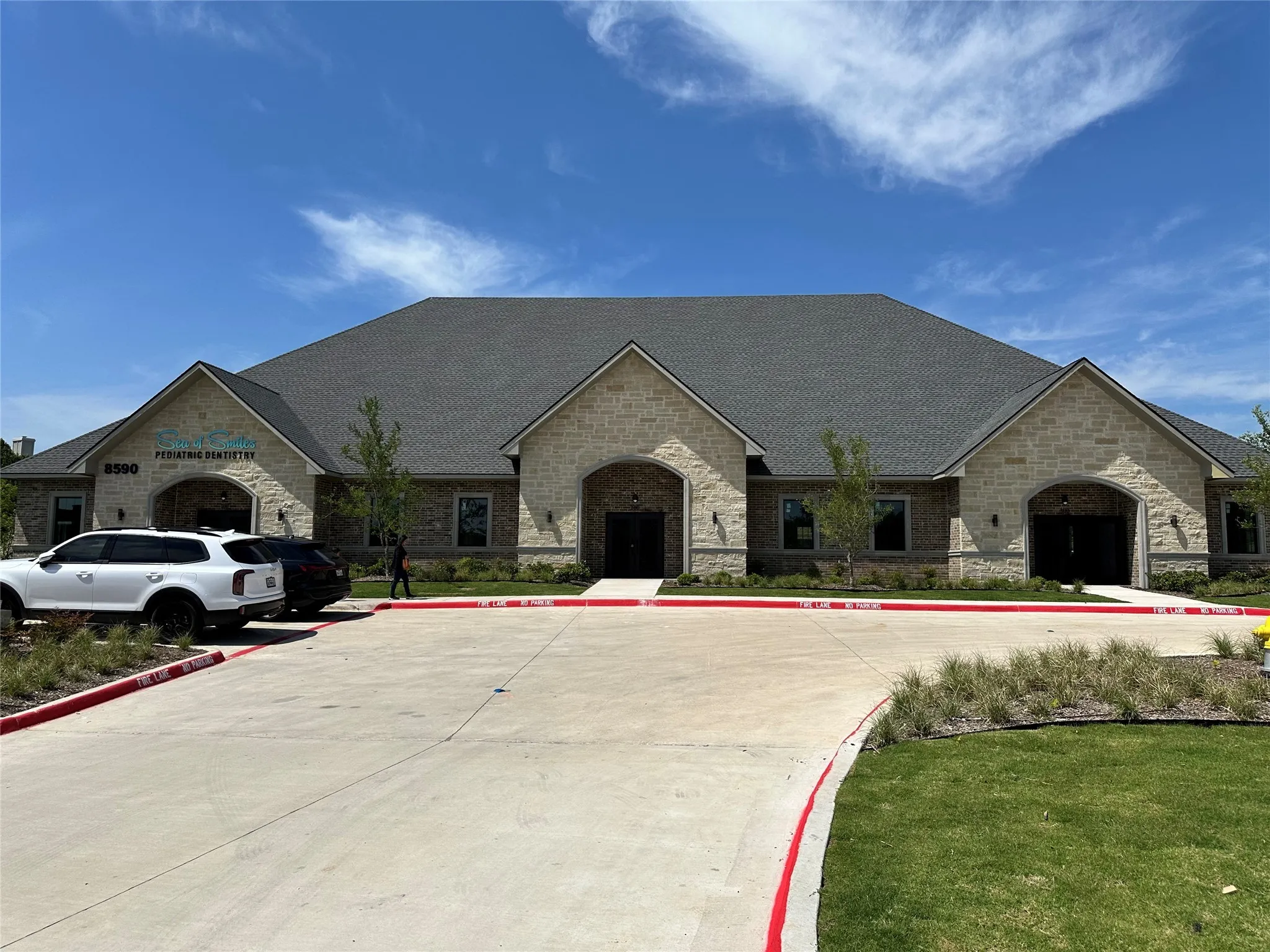 French country inspired facade with a front lawn