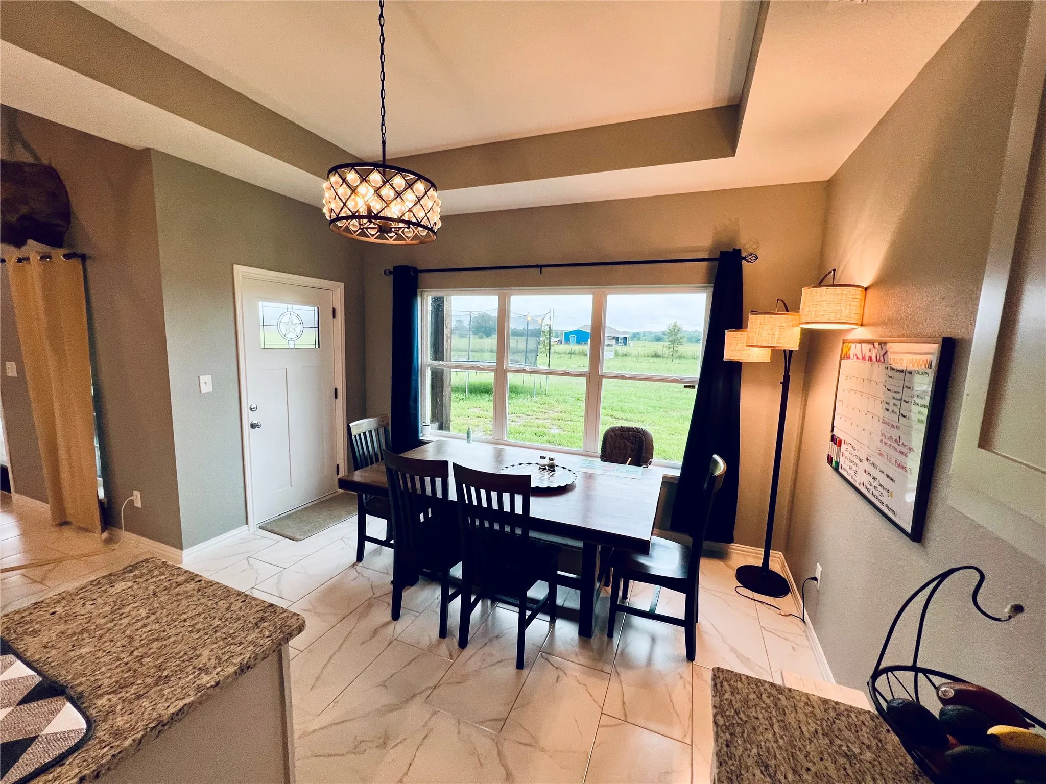 Dining room featuring a raised ceiling and light tile floors