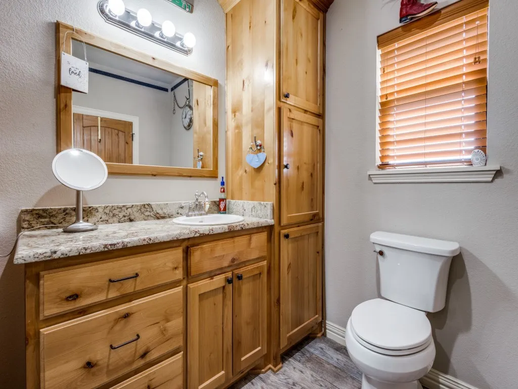 Bathroom with wood-type flooring, vanity, and toilet