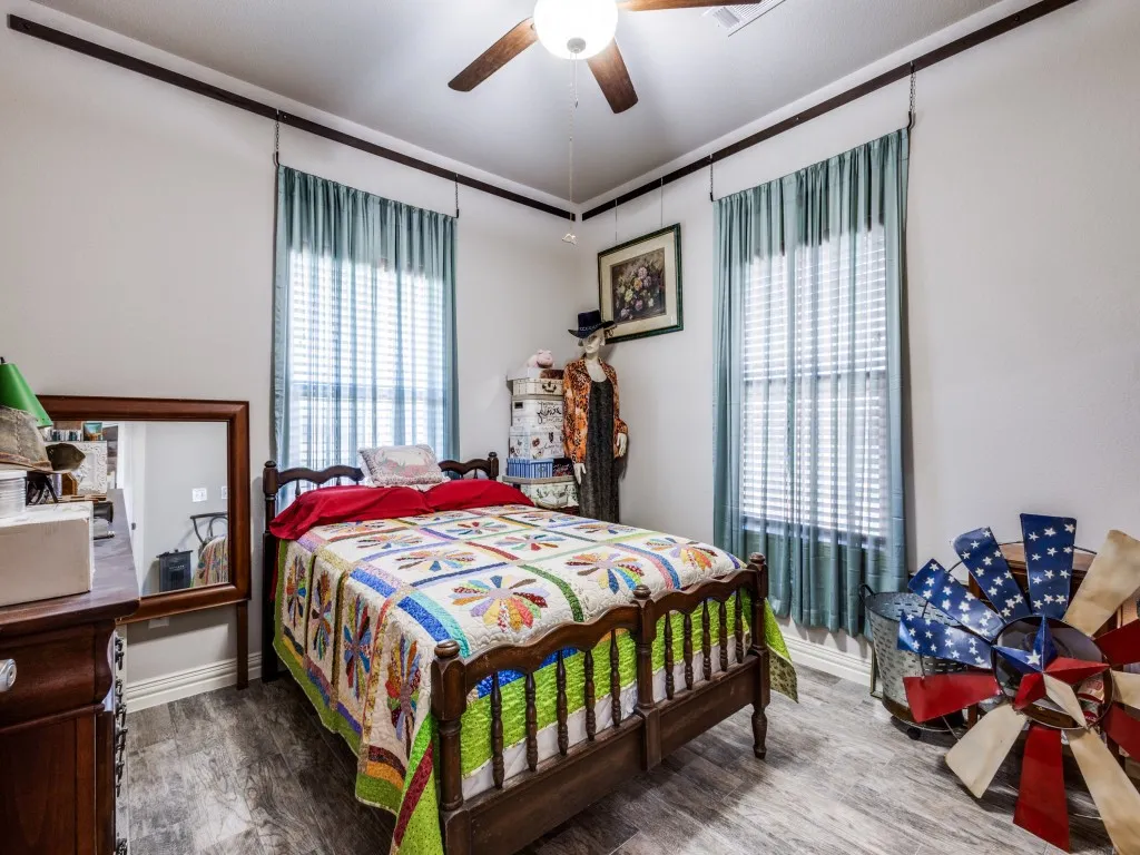 Bedroom with dark hardwood / wood-style floors and ceiling fan