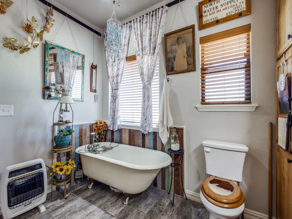 Bathroom with wood-type flooring, toilet, and a bath