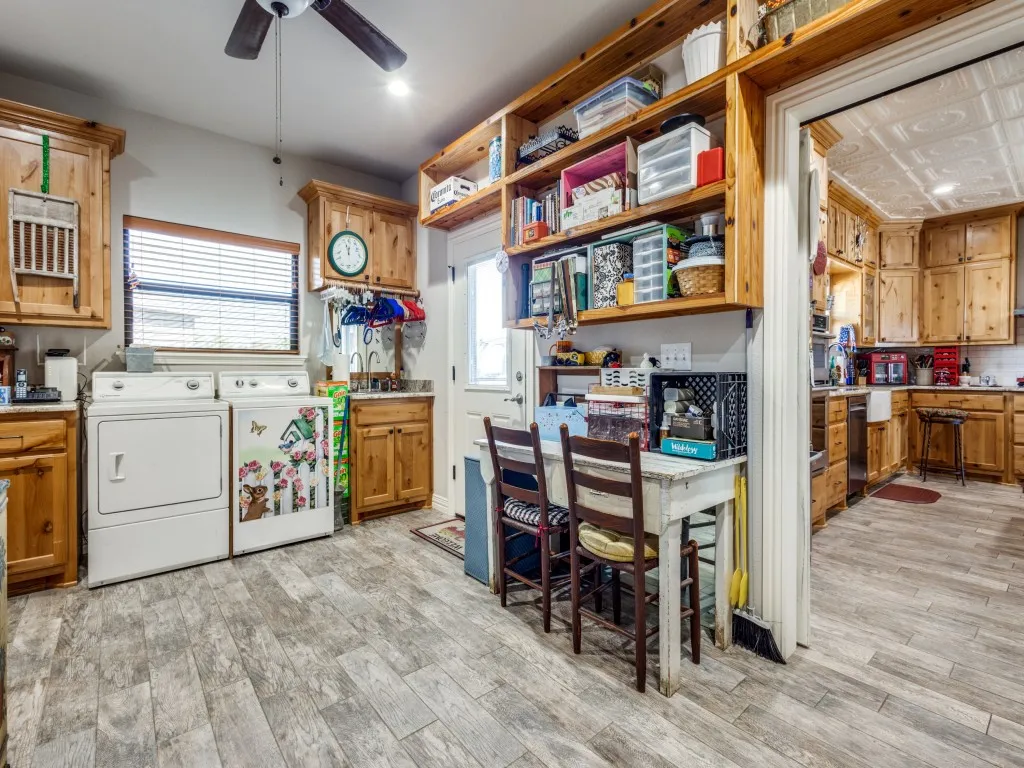 Kitchen with light hardwood / wood-style flooring, washing machine and dryer, and ceiling fan