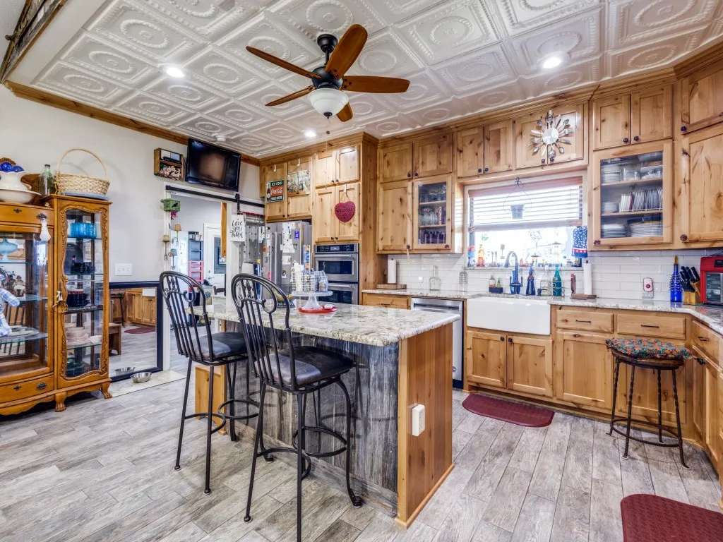 Kitchen with light stone counters, a center island, a breakfast bar, sink, and stainless steel appliances