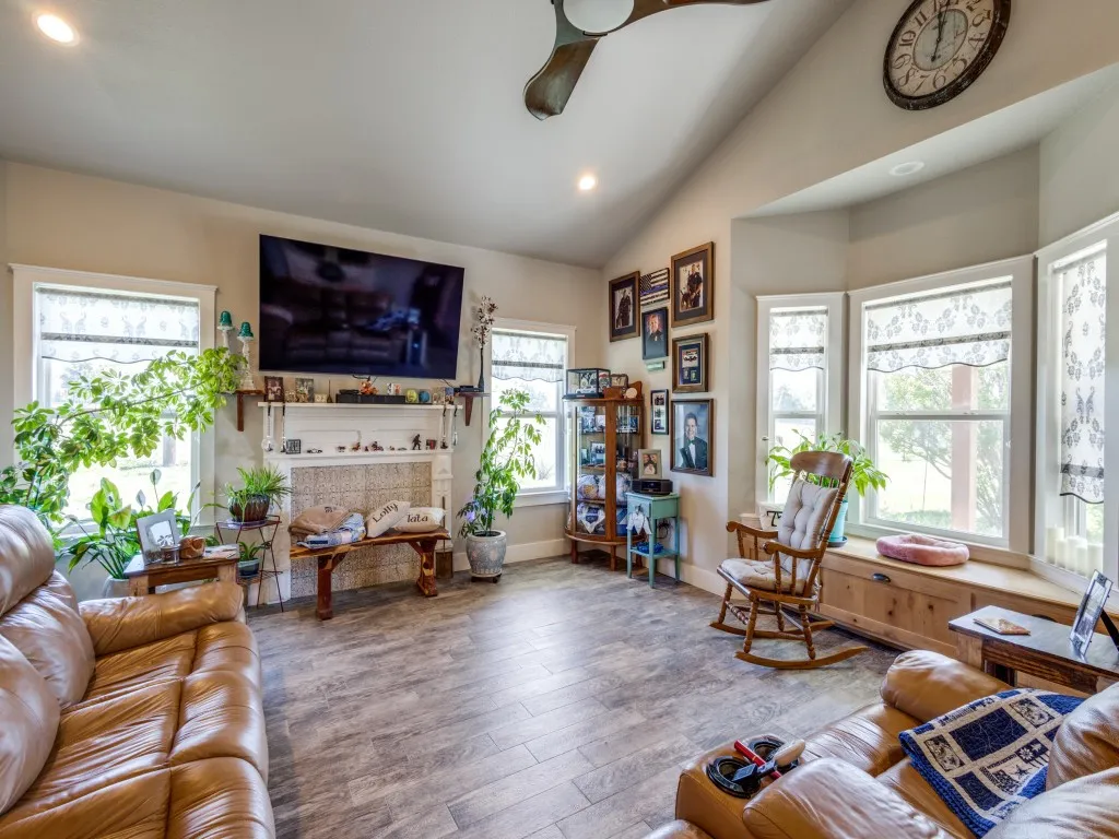 Living room featuring lofted ceiling, light hardwood / wood-style floors, ceiling fan, and a fireplace