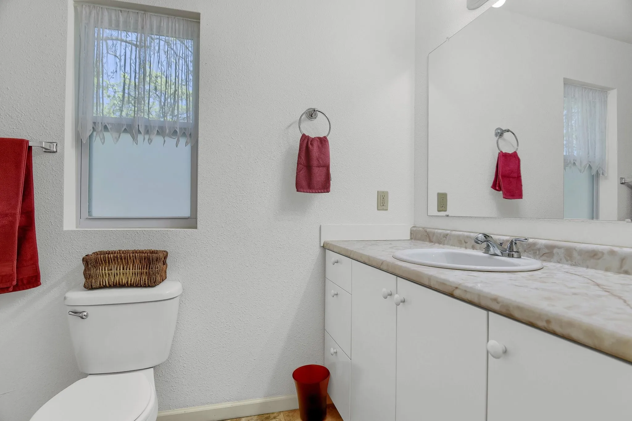 Bathroom with toilet and vanity with extensive cabinet space