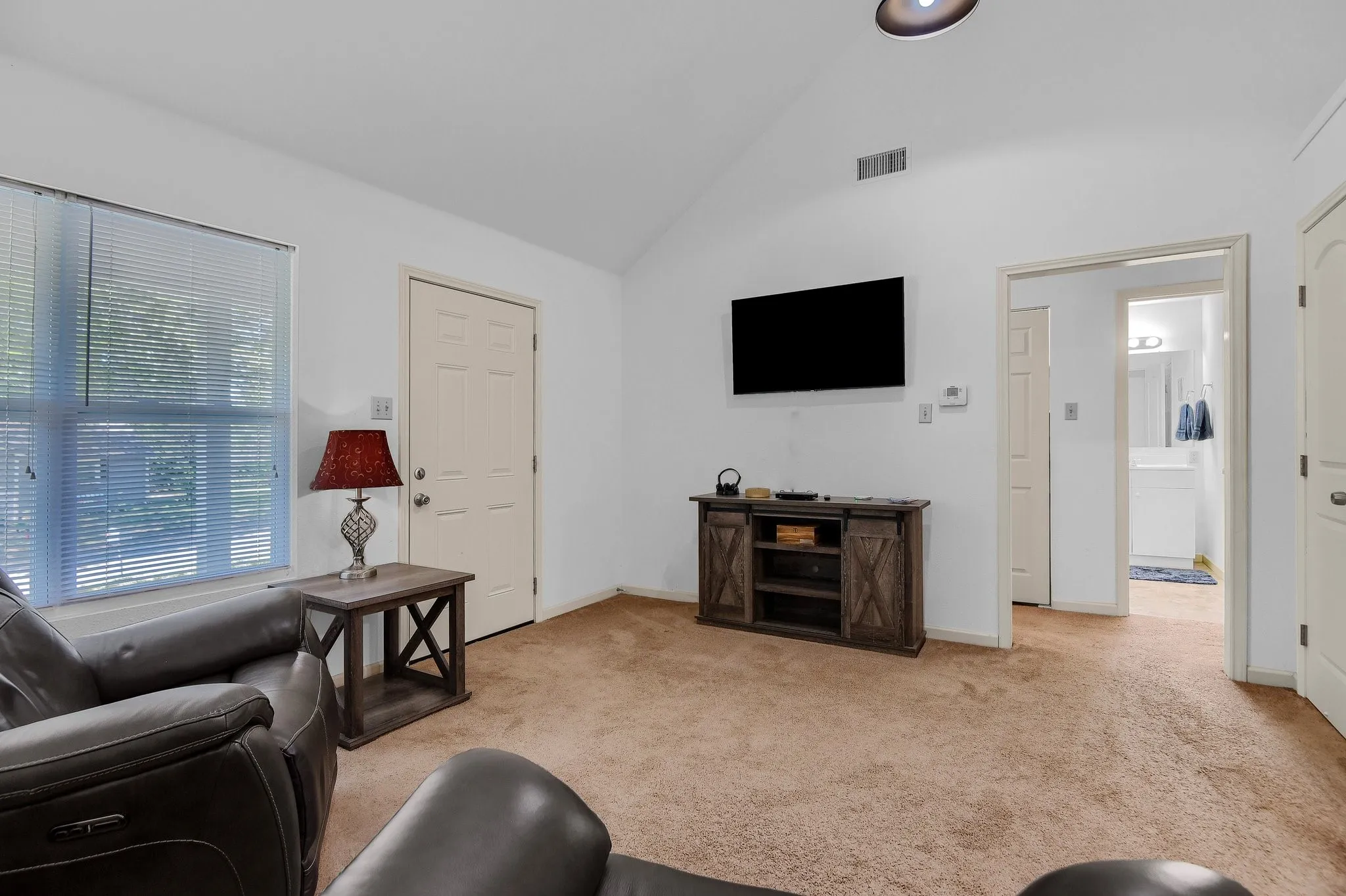 Carpeted living room with vaulted ceiling