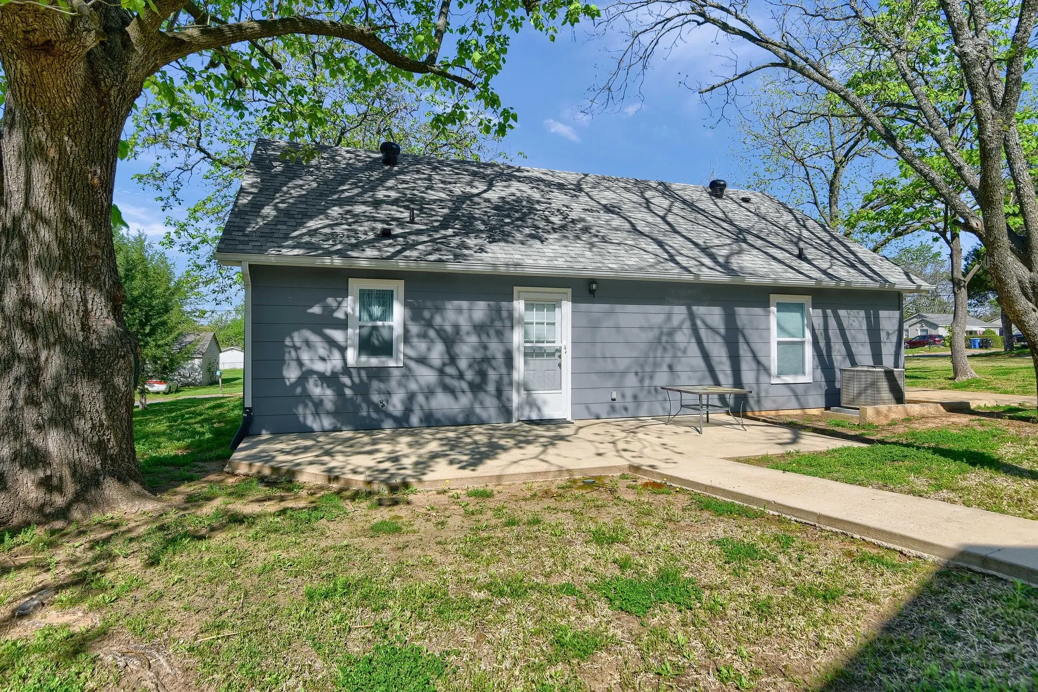 Back of house with a lawn and a patio