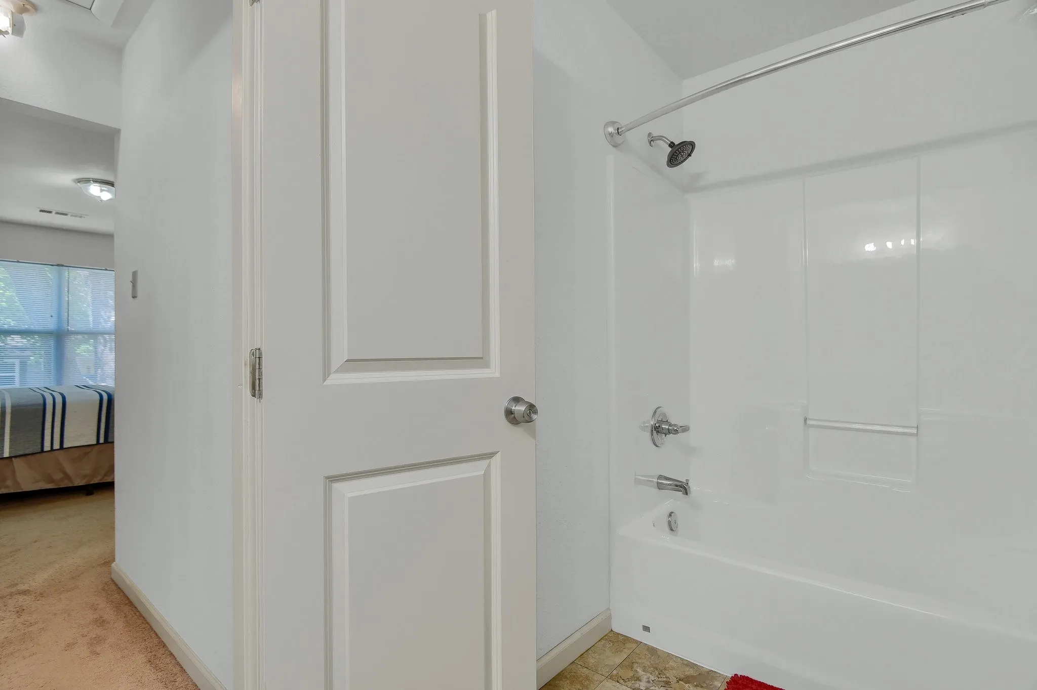 Bathroom with tile floors and washtub / shower combination