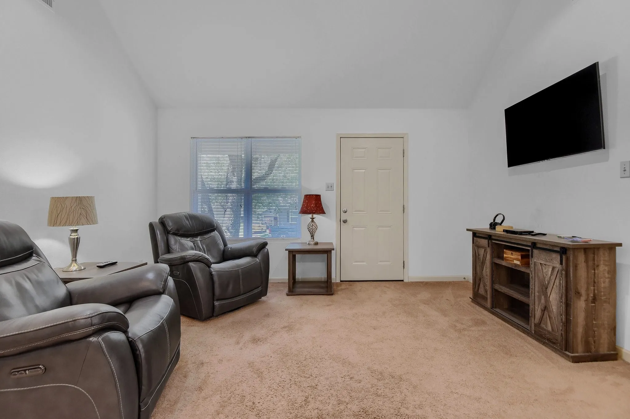 Living room featuring light carpet and vaulted ceiling