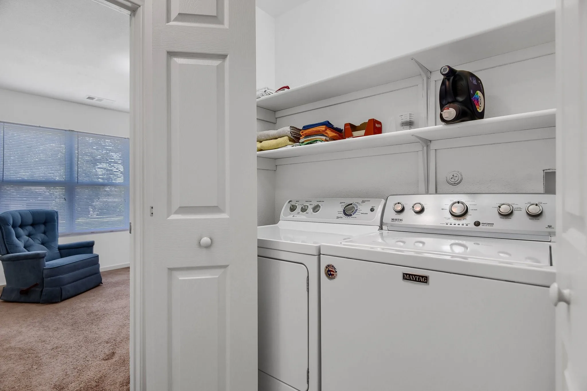 Laundry room with washing machine and clothes dryer and light carpet