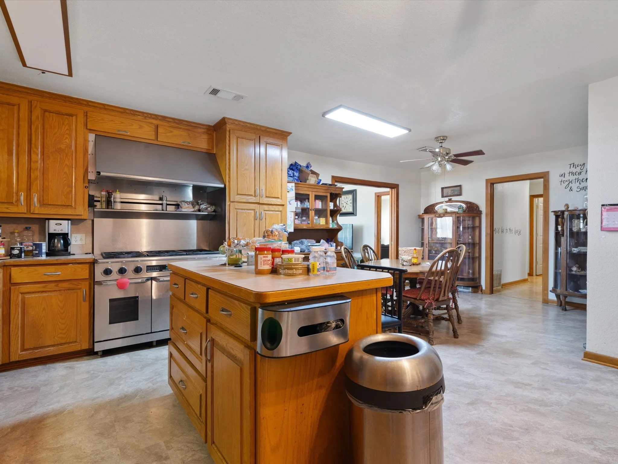Kitchen with range with two ovens, a center island, and ceiling fan
