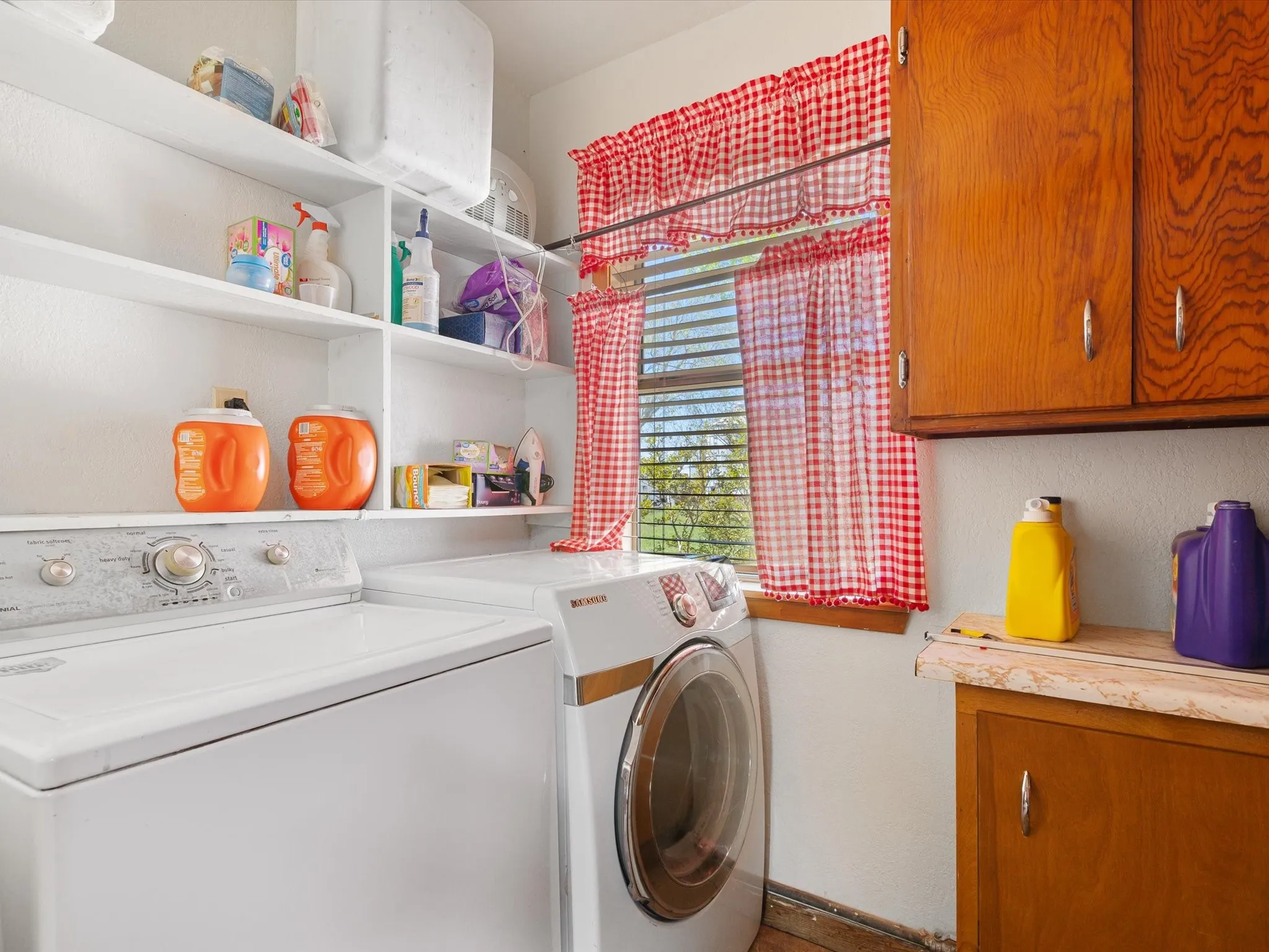 Clothes washing area featuring washer and dryer and cabinets