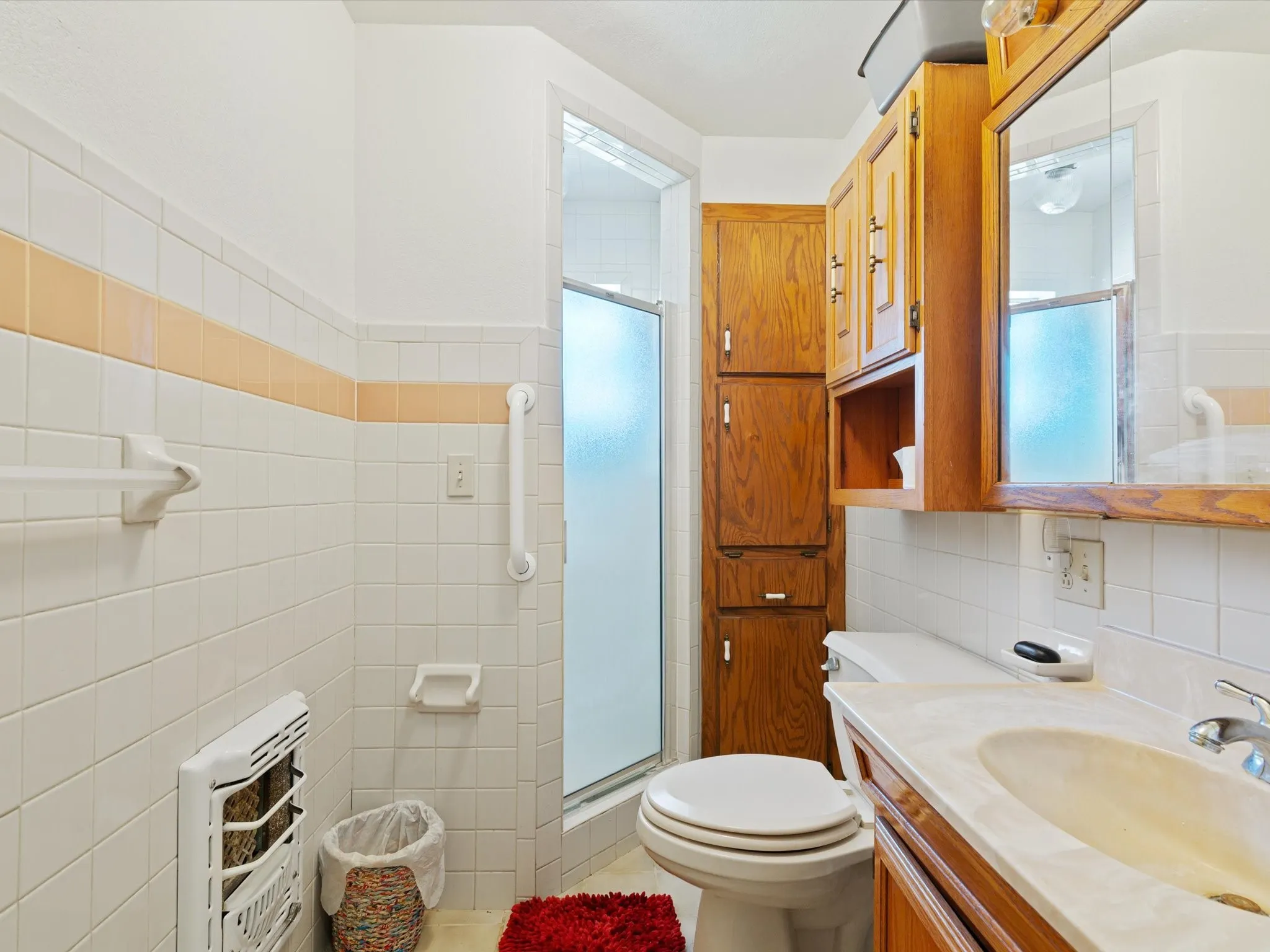 Bathroom featuring toilet, an enclosed shower, tile walls, vanity, and tasteful backsplash