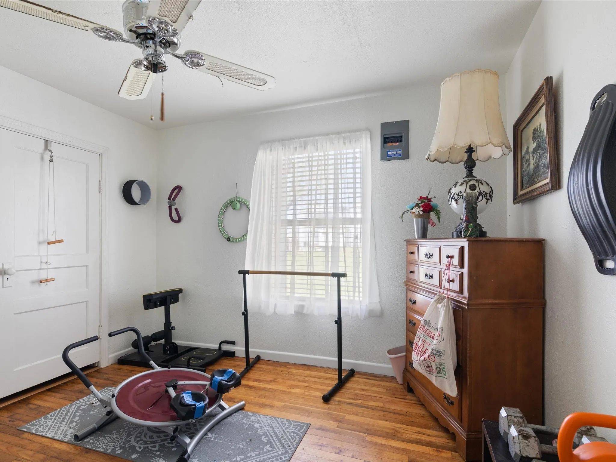 Exercise area with ceiling fan and light wood-type flooring