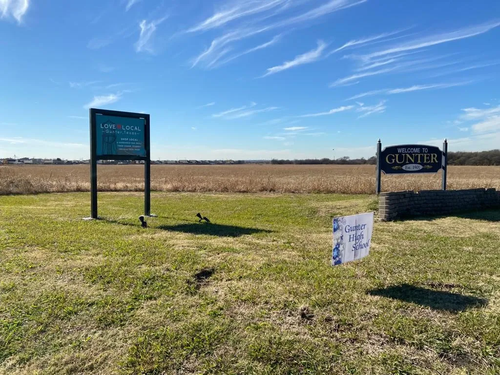 Community / neighborhood sign featuring a lawn