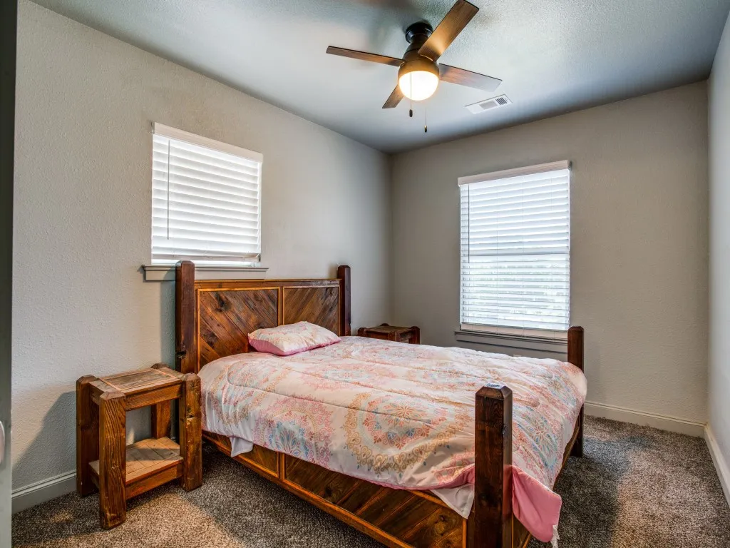 Second living quarters first bedroom featuring carpeted floors, great closet space, and  ceiling fan