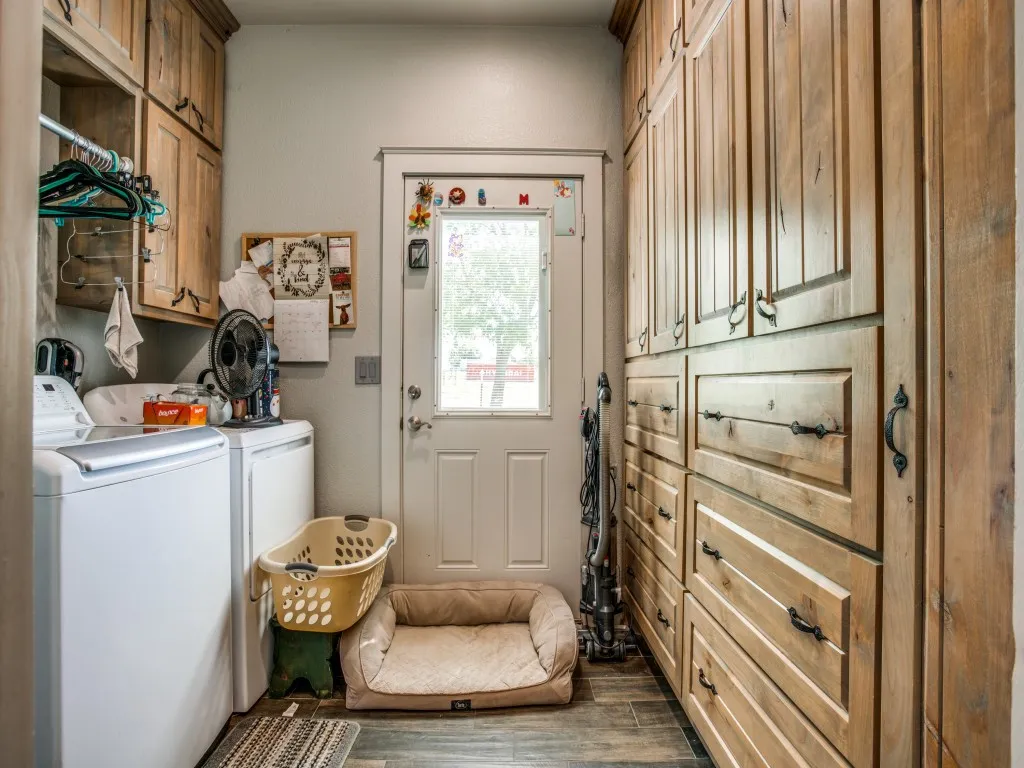 Main house doorway to back yard from utility room with dark hardwood / wood-style flooring
