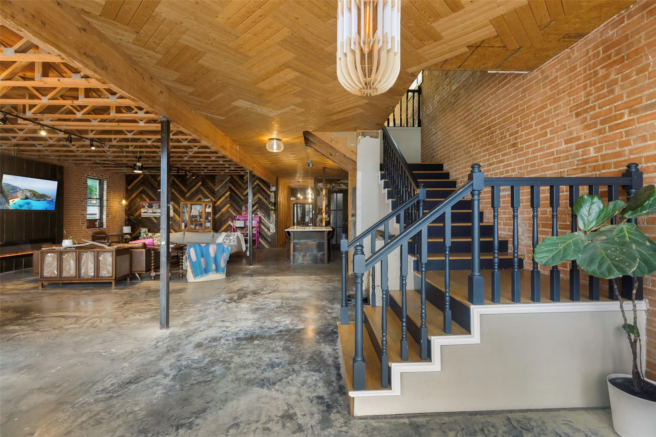 Stairway featuring a notable chandelier and brick wall